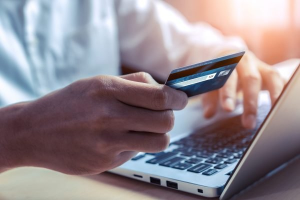 AdobeStock_306701518 (3) Young man use credit card for shopping payment online on laptop computer application or website. E-commerce and online shopping concept.